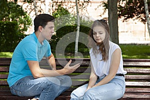 Conflicted couple not talking to each other seated on a wooden bench in park