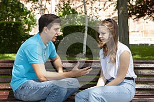 Conflicted couple not talking to each other seated on a wooden bench in park