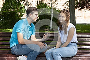 Conflicted couple not talking to each other seated on a wooden bench in park