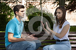 Conflicted couple not talking to each other seated on a wooden bench in park