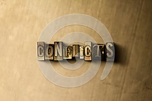 CONFLICTS - close-up of grungy vintage typeset word on metal backdrop