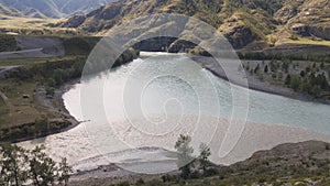 The confluence of Chewie and Katun river in the Altai. The Katun river is turquoise, the Chuya river is dirty gray. Summer