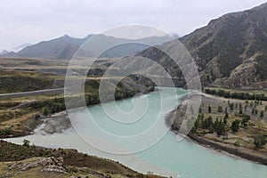 The confluence of two rivers of different colors Chuya and Katun into one. Mountain landscape, Altai Republic, Russia