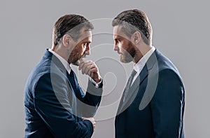 confrontation of two businessmen in suit. photo of businessmen has confrontation look