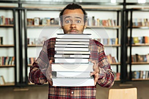 Confused african man student standing in library