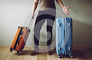 Confused air passenger standing with luggage  stranded in airport.