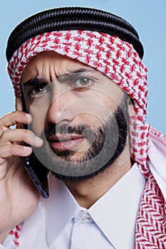 Confused arab chatting on smartphone