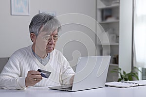 Asian elderly senior retired man, stressed worried sad frustrated male having problem with paying, buying online