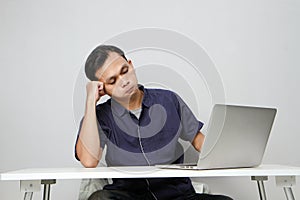 confused asian man in workplace white sitting in front of laptop computer. isolated background