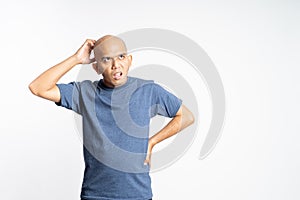 confused bald man holding his bald head