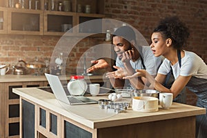 Confused black couple cooking dinner together