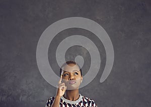 Confused black woman looking up, thinking, making choice, doubting, questioning something