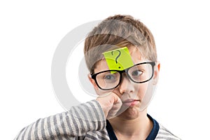 Confused boy thinking with question mark on sticky note on forehead