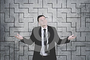 Confused businessman against complicated maze drawing background