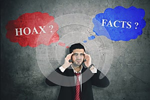 Confused businessman with hoax or fact