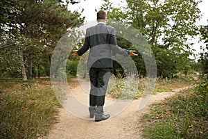 Confused businessman standing at crossroads. Concept of choice