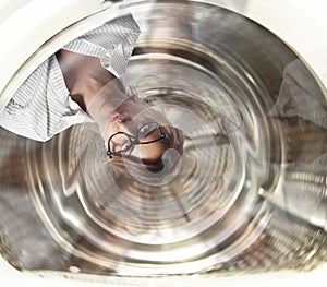 Confused businesswoman has dizziness inside a washing machine. Concept of stress and overwork