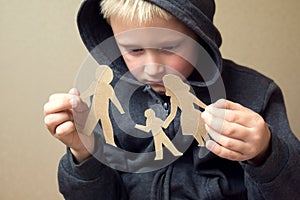 Confused child with broken paper family