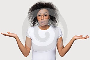 Confused doubtful baffled black woman shrugging looking at camera