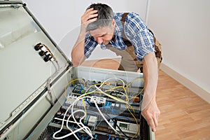 Confused electrician looking at fuse box