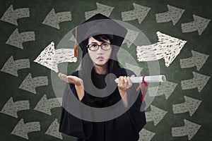Confused female student in graduation gown