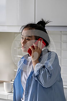 Confused frustrated Asian woman has difficult phone call talk listen to unexpected bad news at home.