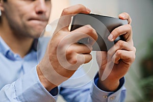 Confused frustrated male manager looking at mobile phone