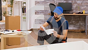 Confused furniture assembly worker while reading instructions