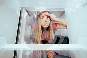Confused Girl Looking into Her Empty Refrigerator
