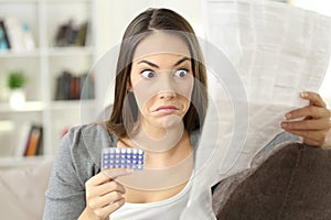 Confused girl reading leaflet of contraceptive pills photo