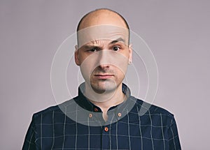 Confused guy. Puzzled young bald man