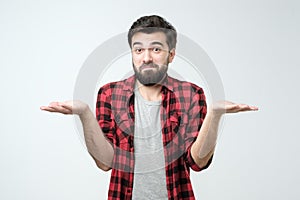 Confused hispanic man giving I dont know gesture on white background. photo