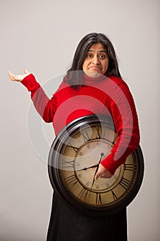 Confused Hispanic Woman Holds Clock Under Arm Unaware Of Future