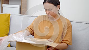Confused lady contemplates misdelivered package, infuriated by shipping mistake, shoddy delivery.