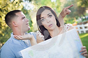 Confused and Lost Mixed Race Couple Looking Over Map Outside