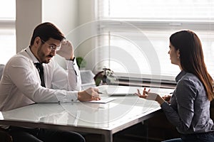 Confused male hr manager listening to female job applicant.