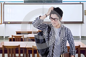 Confused male student standing in class