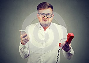 Confused man with different types of phones