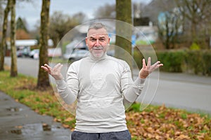 Confused man gesturing showing his ignorance outdoors