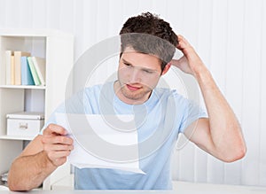 Confused man looking at paper