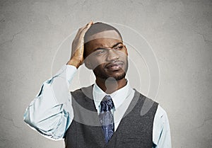 Confused man looks up on gray background