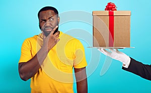 Confused man is suspicious about a gift. concept of options, confusion, indecision photo