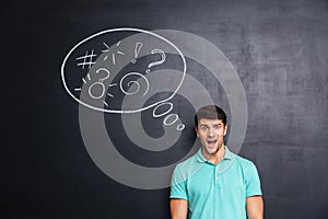 Confused man thinking about problem with blackboard behind him