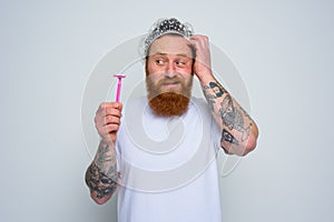 confused man wants to adjust the beard with a razor blade