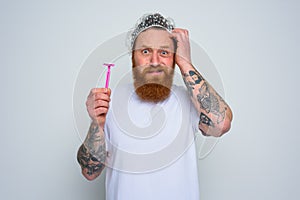 confused man wants to adjust the beard with a razor blade