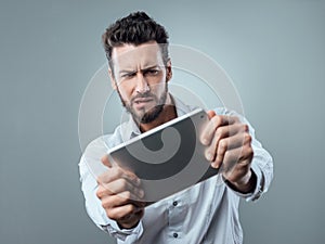 Confused man watching his tablet