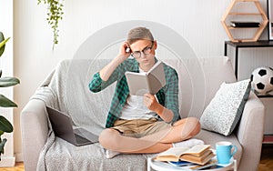 Confused nerd boy reading book, home education concept