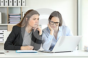 Confused office workers consulting online information