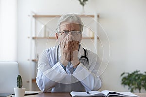 Confused old mature doctor therapist regretting diagnosis mistake.