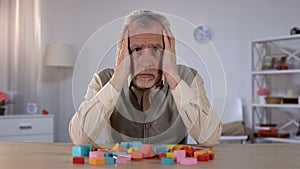 Confused pensioner trying remember to combine blocks, brain disease, alzheimer